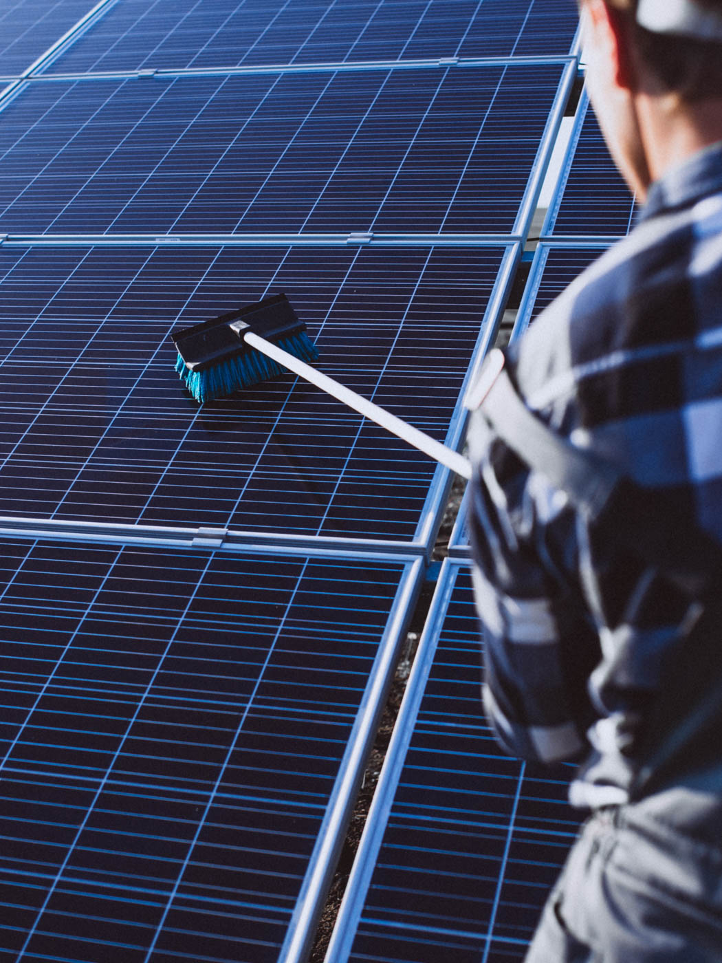 Mann reinigt Photovoltaikanalge