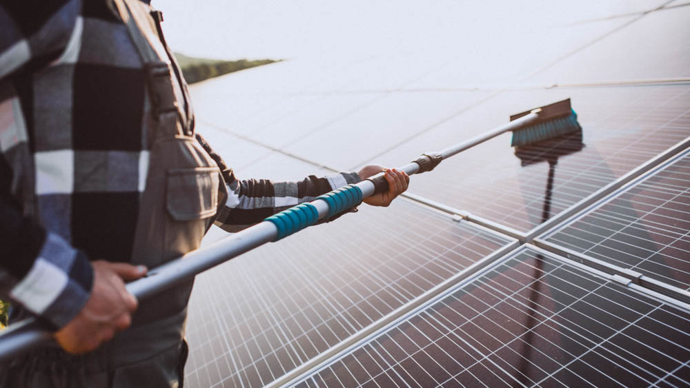 Man worker in the firld by the solar panels
